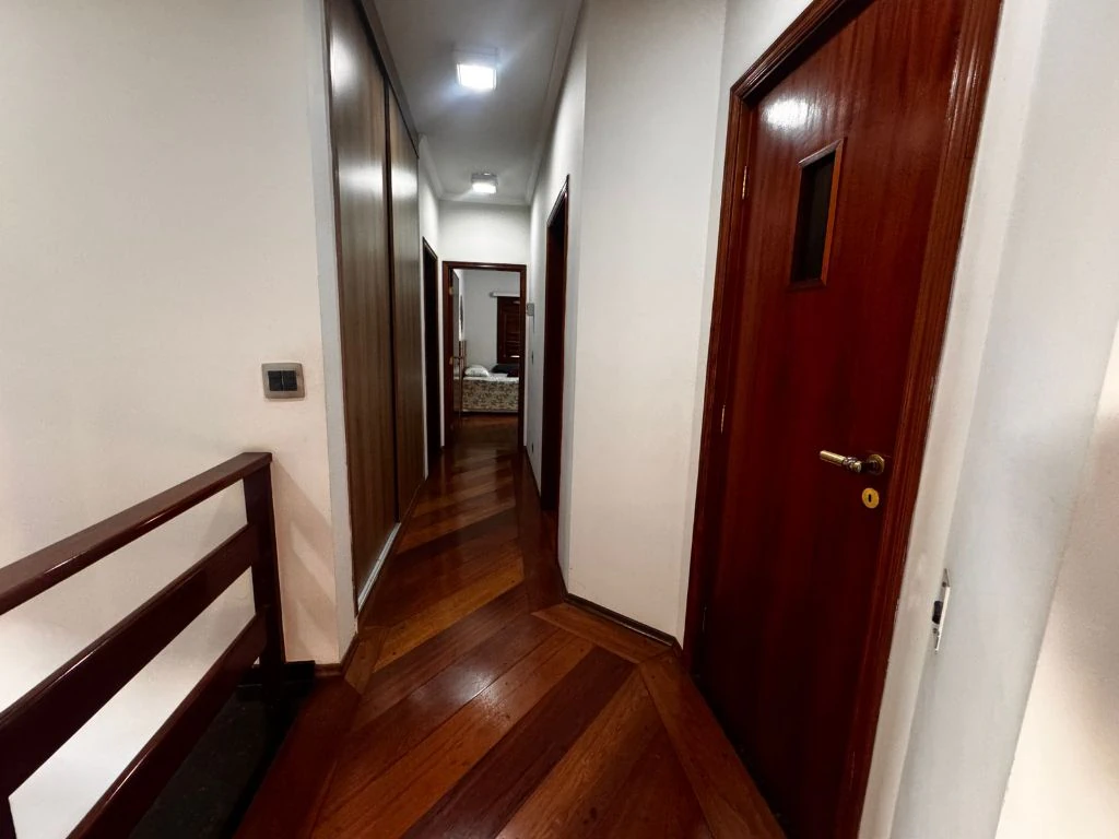Corredor de acesso aos quartos, em piso de madeira