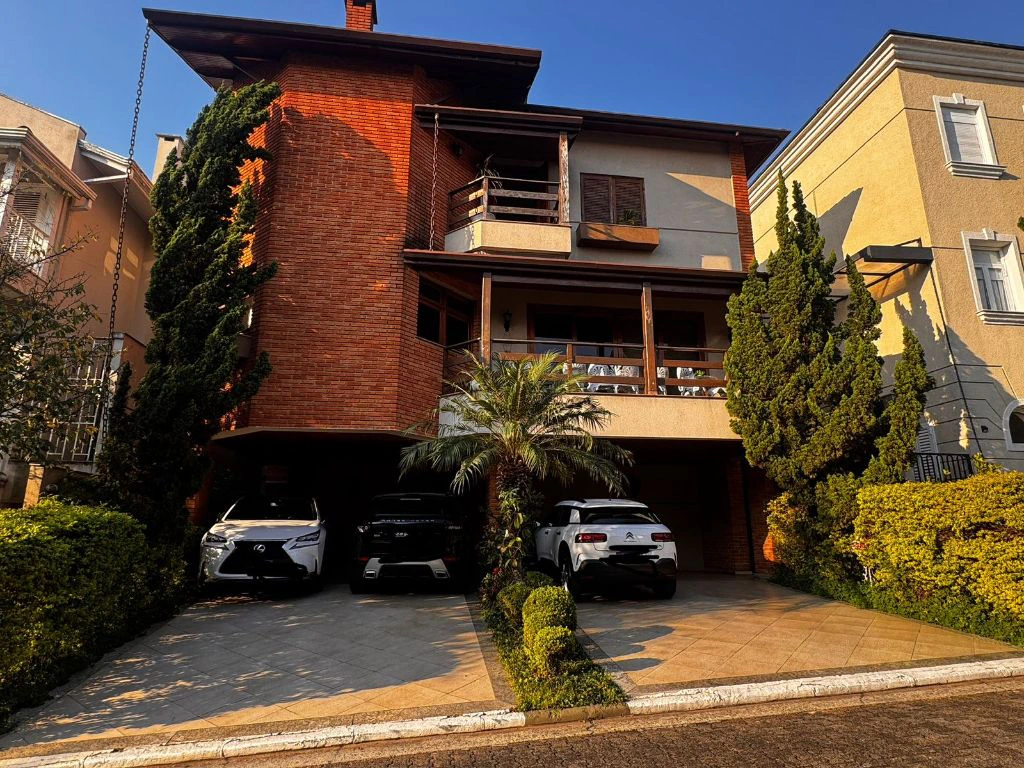 Fachada da casa, com varanda no segundo andar e vagas de garagem cobertas