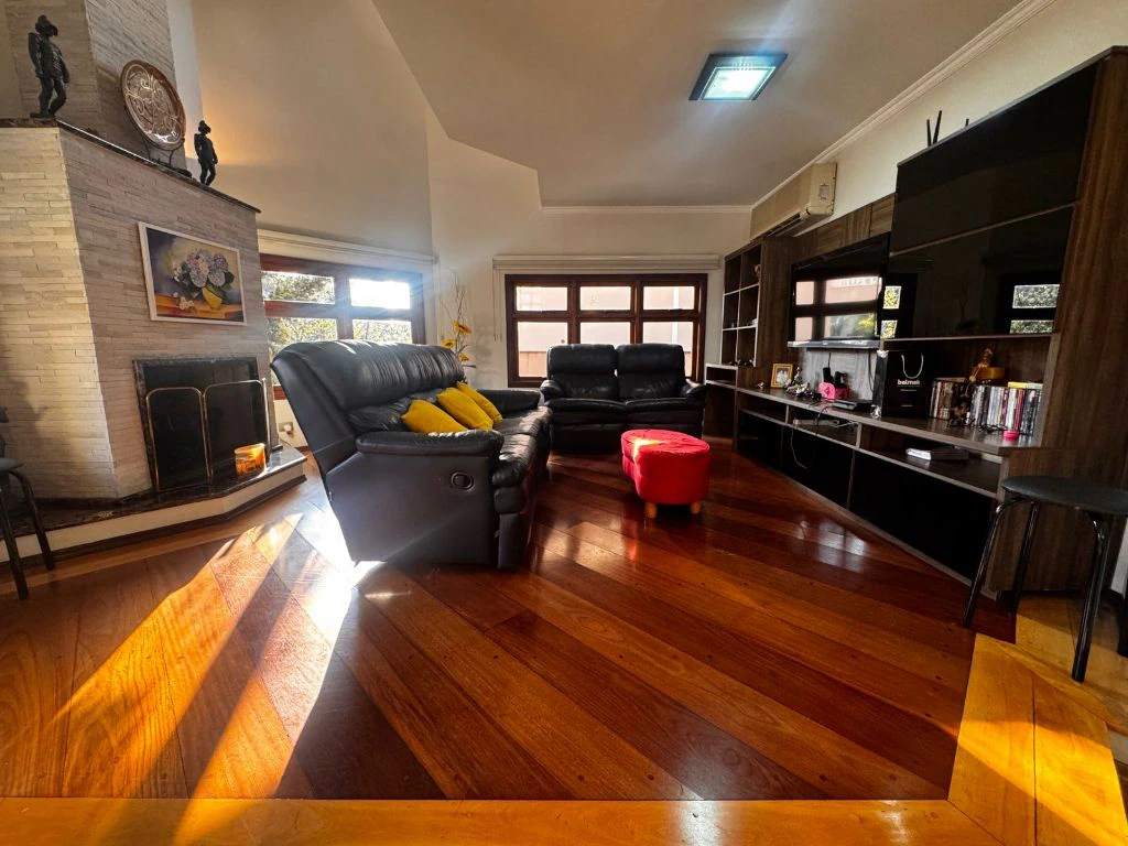 Sala de estar com lareira e sofás de couro